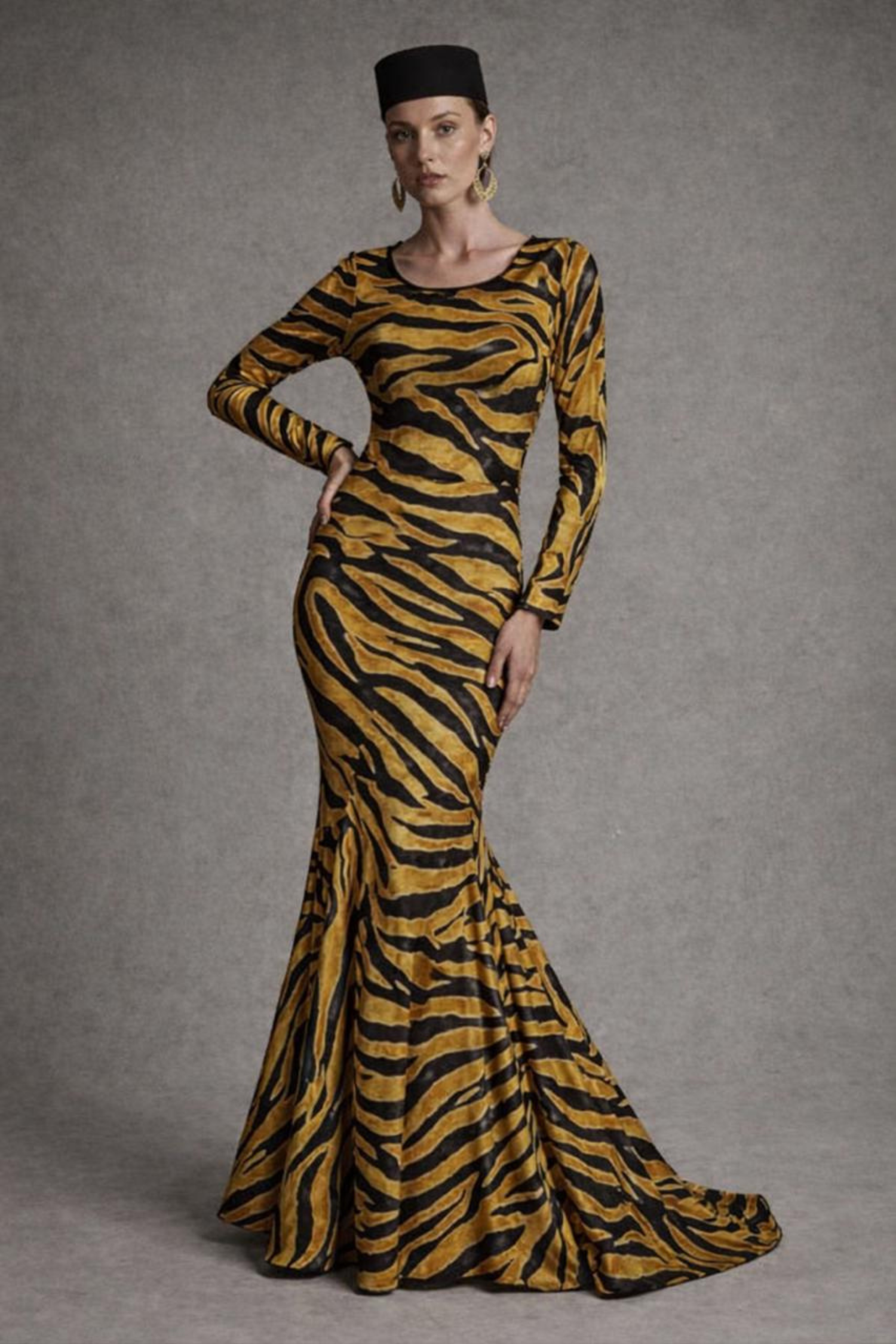 Woman wearing a zebra print dress with long sleeves against a gray background