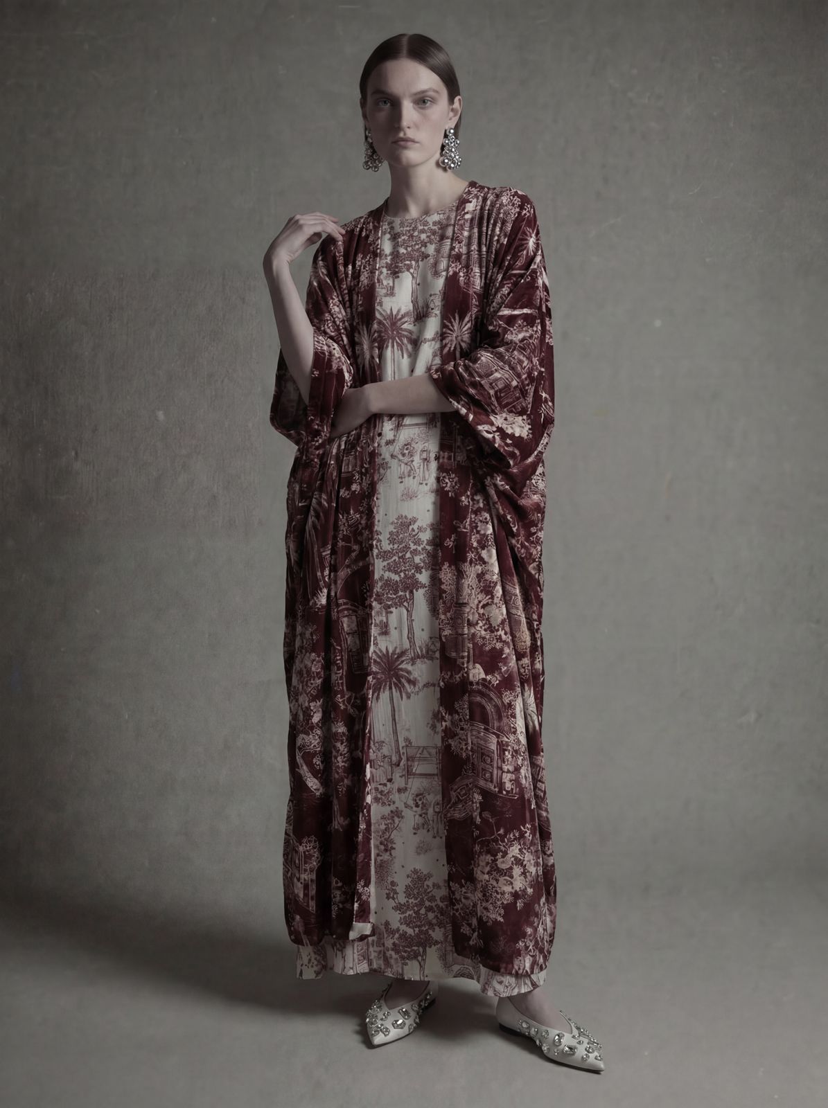 Woman wearing a long, patterned dress against a gray background